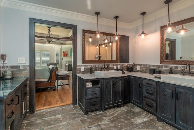 interior space with a sink, ornamental molding, ceiling fan, and pendant lighting