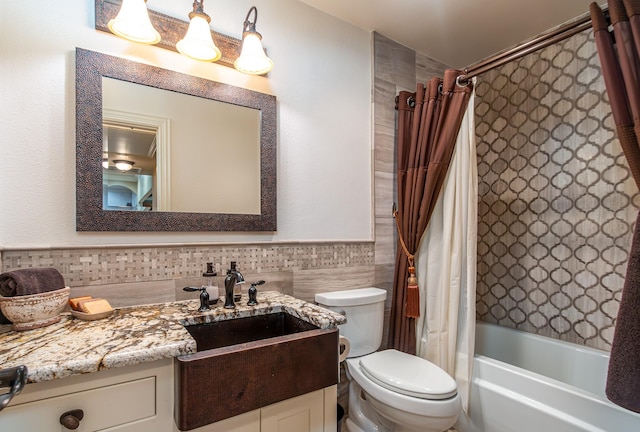 bathroom with toilet, vanity, shower / bath combo with shower curtain, and tile walls