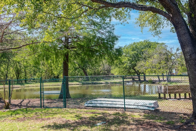 exterior space with a water view, fence, and a gate
