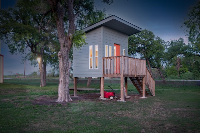 back of property with a yard, fence, and stairs