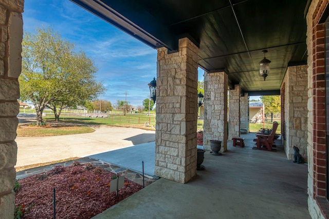 view of patio featuring a porch and fence