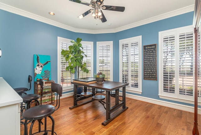 dining room with crown molding, ceiling fan, light wood finished floors, and baseboards
