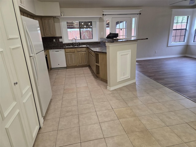 kitchen with light tile patterned flooring, a sink, white appliances, and plenty of natural light