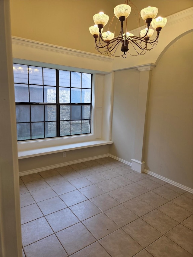 empty room featuring baseboards, arched walkways, a chandelier, crown molding, and tile patterned floors