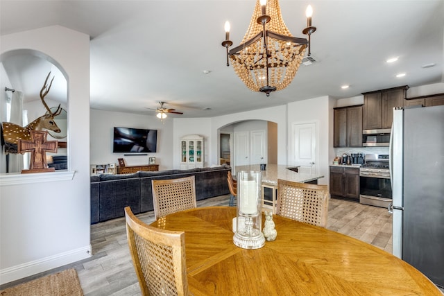 dining room featuring recessed lighting, light wood-style flooring, visible vents, arched walkways, and ceiling fan with notable chandelier