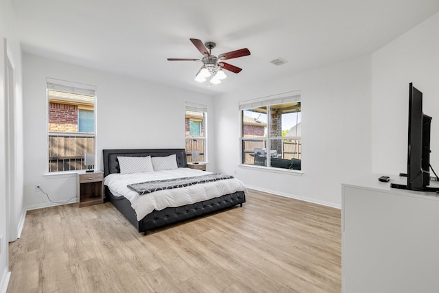 bedroom with ceiling fan, baseboards, and wood finished floors