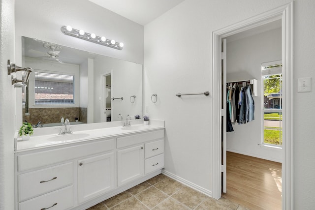 bathroom featuring a sink, double vanity, and a healthy amount of sunlight