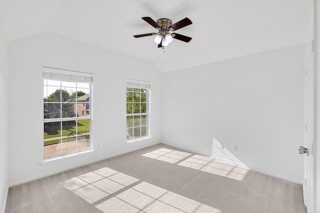 spare room featuring carpet, ceiling fan, baseboards, and lofted ceiling