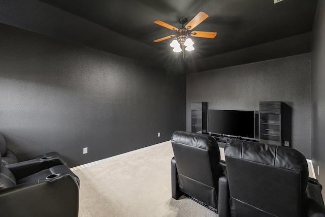 carpeted home theater room featuring baseboards and a ceiling fan