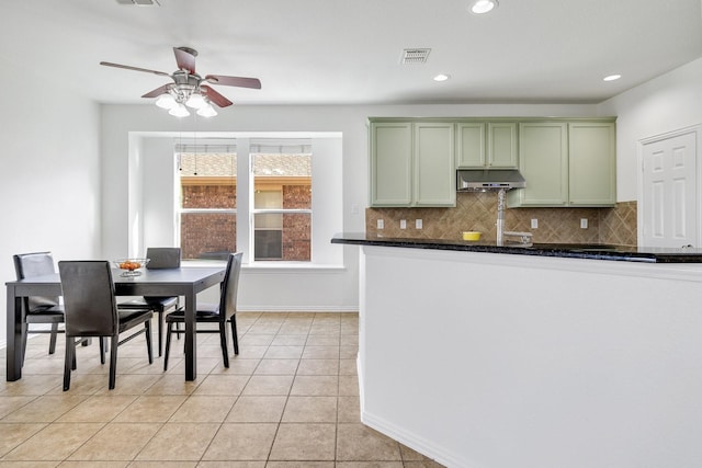 kitchen with ceiling fan, visible vents, under cabinet range hood, backsplash, and green cabinetry