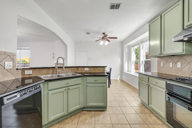 kitchen with a sink, black appliances, and green cabinetry