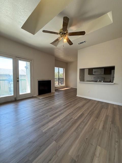 7126 Holly Hill Dr Unit 304, Dallas, TX 75231 - unfurnished living room featuring baseboards, dark wood-style flooring, ceiling fan, and visible vents