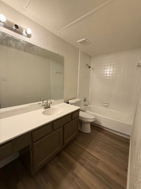 7126 Holly Hill Dr Unit 304, Dallas, TX 75231 - full bath featuring vanity, toilet, visible vents, shower / bathing tub combination, and wood finished floors