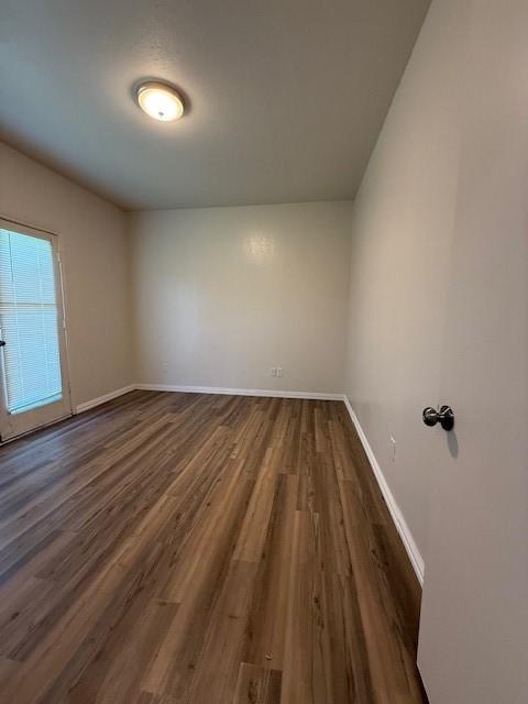 7126 Holly Hill Dr Unit 304, Dallas, TX 75231 - unfurnished room featuring dark wood-type flooring and baseboards