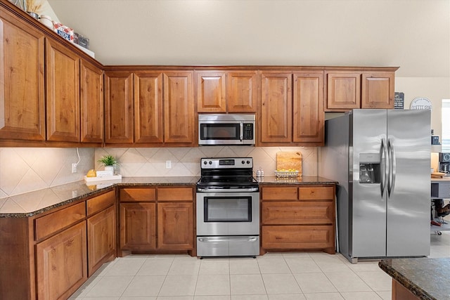 191 Cardiff Ln, Waxahachie, TX 75167 - kitchen featuring brown cabinets, backsplash, light tile patterned floors, and appliances with stainless steel finishes