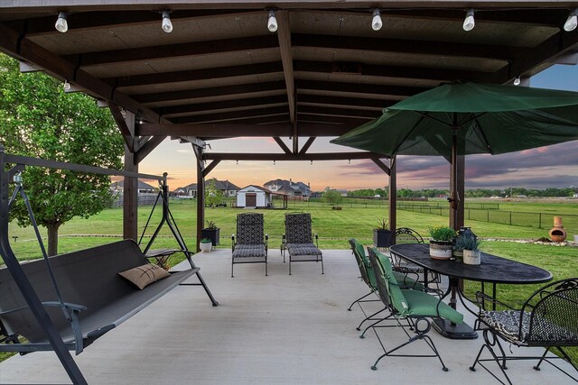 191 Cardiff Ln, Waxahachie, TX 75167 - patio terrace at dusk with a yard, outdoor dining space, a shed, an outbuilding, and a fenced backyard