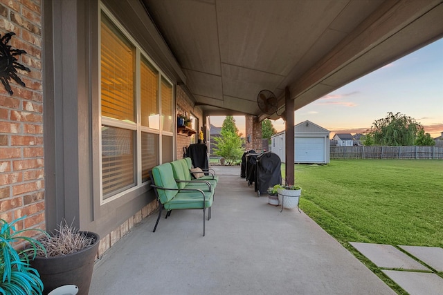 191 Cardiff Ln, Waxahachie, TX 75167 - patio terrace at dusk featuring a yard, fence, and an outbuilding