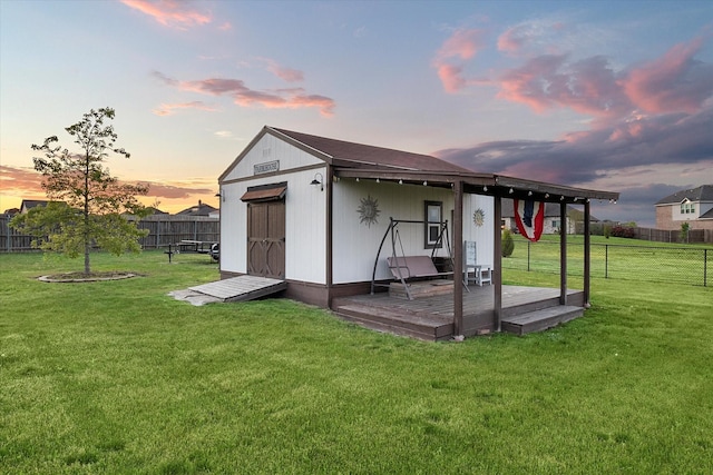191 Cardiff Ln, Waxahachie, TX 75167 - outdoor structure at dusk with a fenced backyard, an outbuilding, and a lawn