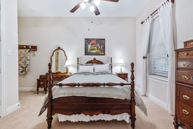 bedroom featuring light colored carpet, baseboards, and ceiling fan
