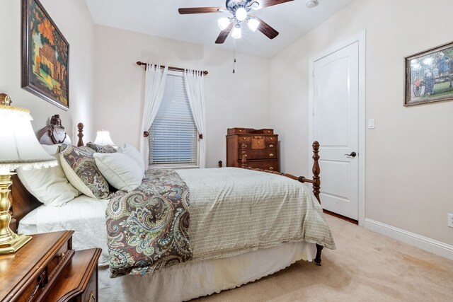 bedroom featuring light colored carpet, baseboards, and ceiling fan