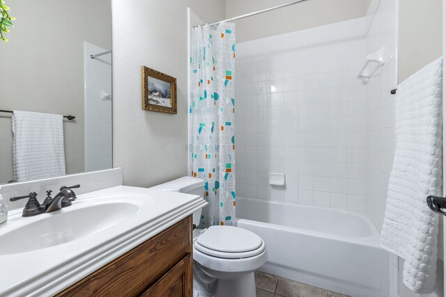 bathroom with shower / tub combo, toilet, vanity, and tile patterned floors