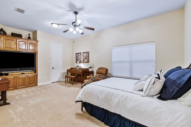 bedroom featuring light colored carpet, a ceiling fan, and baseboards