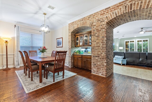 dining space featuring a ceiling fan, dark wood finished floors, baseboards, and ornamental molding