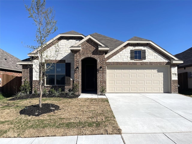 french country inspired facade featuring concrete driveway, a garage, and brick siding