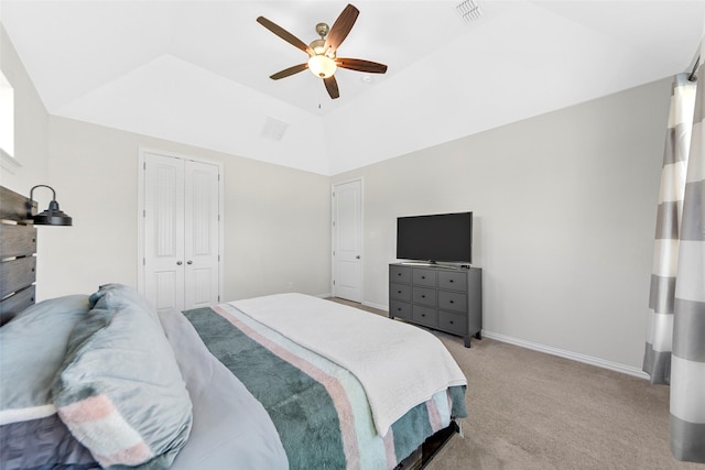 bedroom with ceiling fan, a closet, light colored carpet, visible vents, and lofted ceiling
