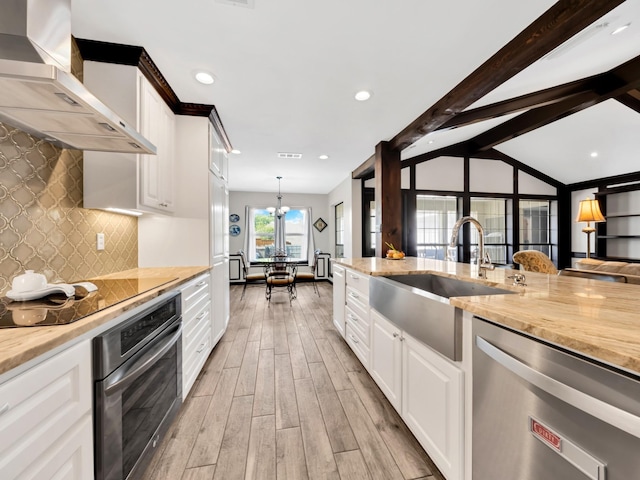 1770 Plummer Dr, Rockwall, TX 75087 - kitchen featuring stainless steel appliances, wall chimney range hood, a sink, light wood finished floors, and tasteful backsplash