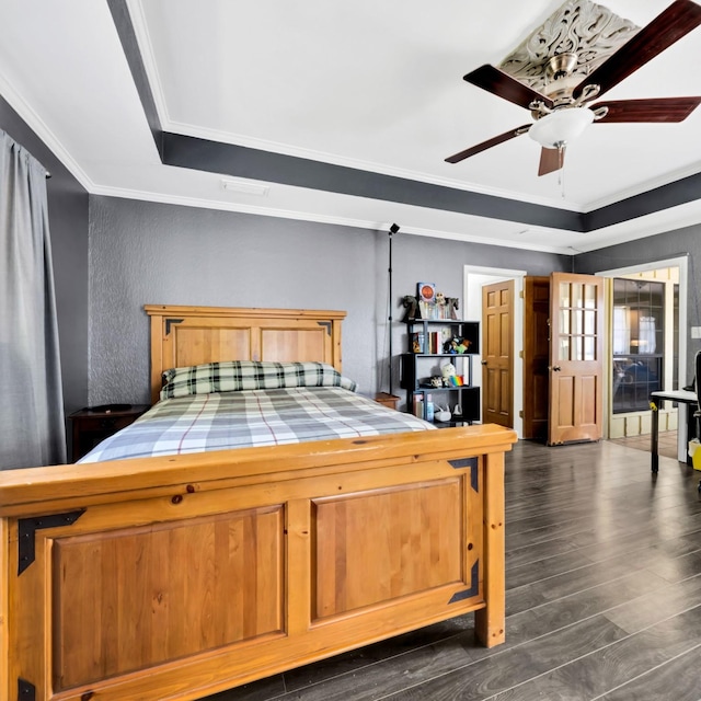 1770 Plummer Dr, Rockwall, TX 75087 - bedroom with ornamental molding, dark wood-style flooring, a textured wall, a ceiling fan, and a tray ceiling