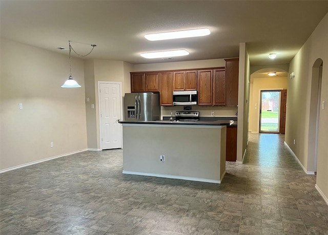 112 Jimmie Birdwell Blvd, Ferris, TX 75125 - kitchen with stainless steel appliances, arched walkways, dark countertops, baseboards, and an island with sink