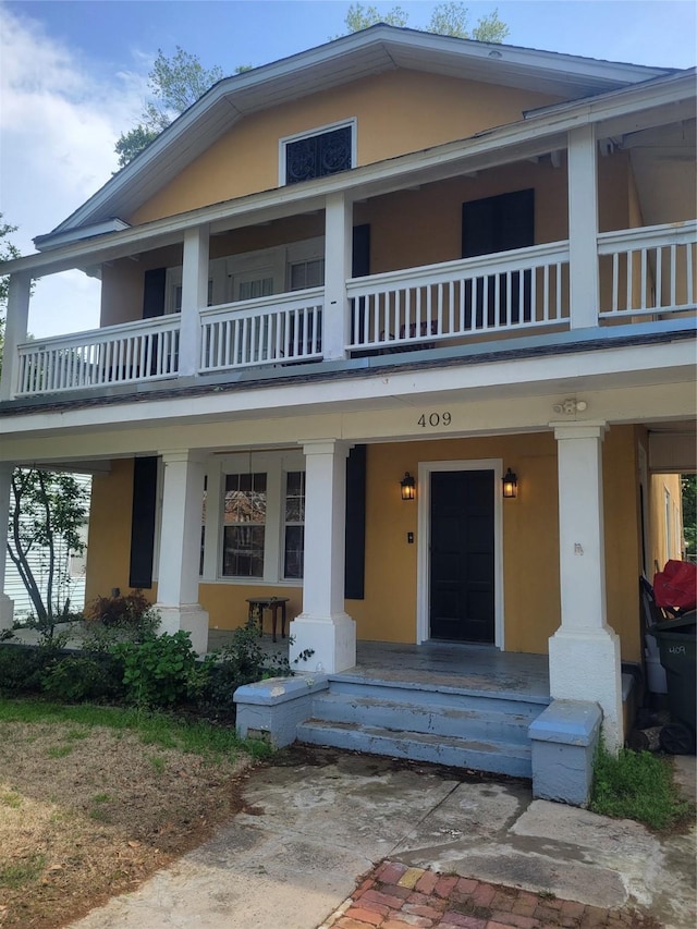 409 Forest Ave, Shreveport, LA 71104 - view of front of house featuring stucco siding, a porch, and a balcony
