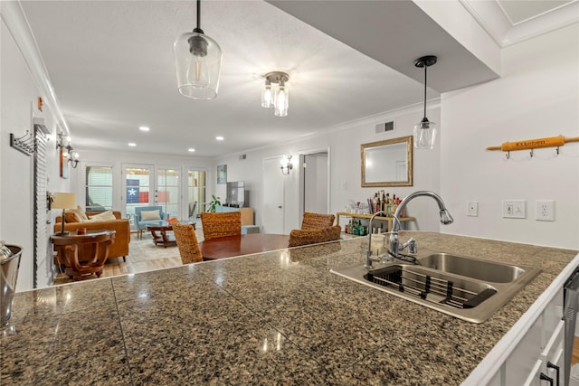 5925 E University Blvd Unit 133, Dallas, TX 75206 - kitchen with visible vents, a sink, crown molding, and hanging light fixtures