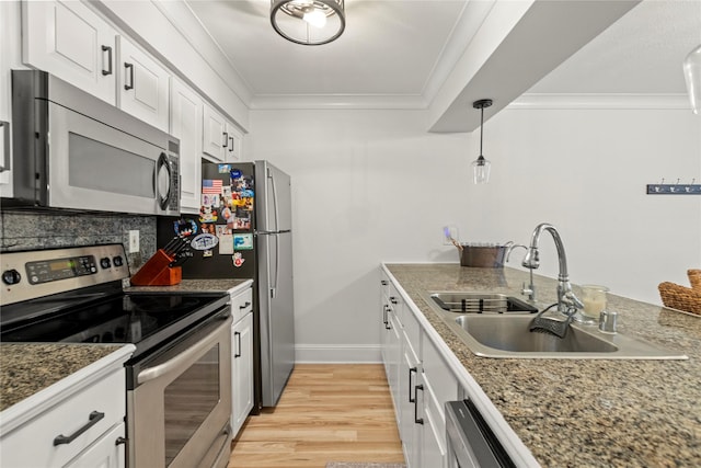 5925 E University Blvd Unit 133, Dallas, TX 75206 - kitchen featuring crown molding, a sink, white cabinets, and stainless steel appliances