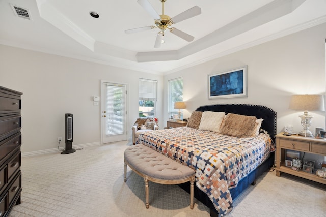bedroom featuring a tray ceiling, ornamental molding, visible vents, light carpet, and access to exterior