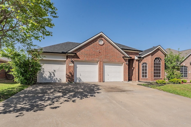 ranch-style house featuring a garage, roof with shingles, brick siding, and driveway