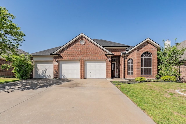 single story home featuring a garage, brick siding, a front lawn, driveway, and roof with shingles