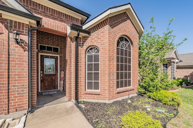 entrance to property featuring brick siding