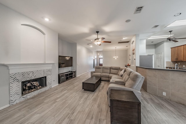 living room with light wood finished floors, visible vents, and ceiling fan