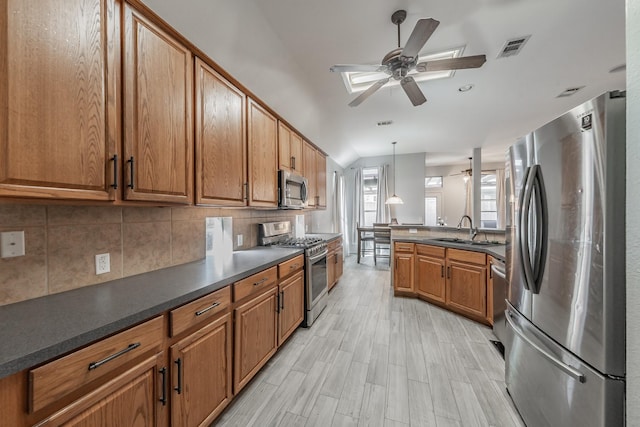 kitchen featuring visible vents, a sink, ceiling fan, appliances with stainless steel finishes, and brown cabinetry