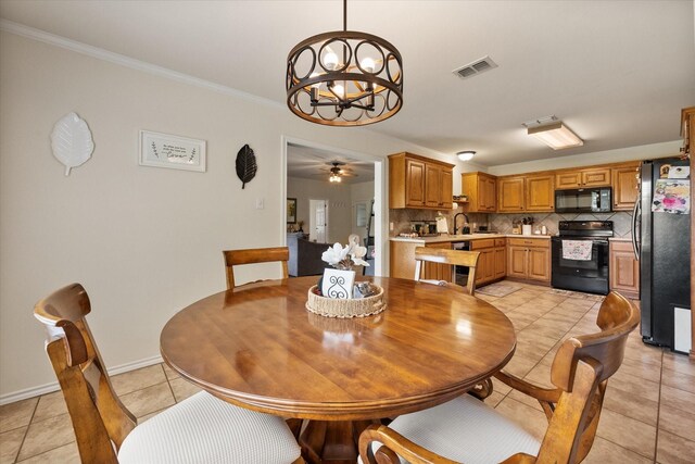 dining room featuring light tile patterned floors, baseboards, visible vents, ceiling fan with notable chandelier, and ornamental molding