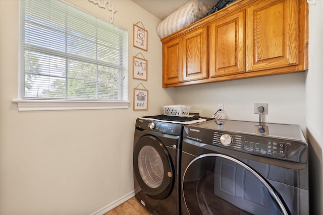 laundry area featuring cabinet space, independent washer and dryer, baseboards, and light tile patterned floors