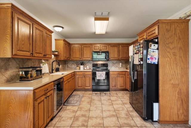 kitchen featuring wine cooler, a sink, brown cabinetry, light countertops, and black appliances