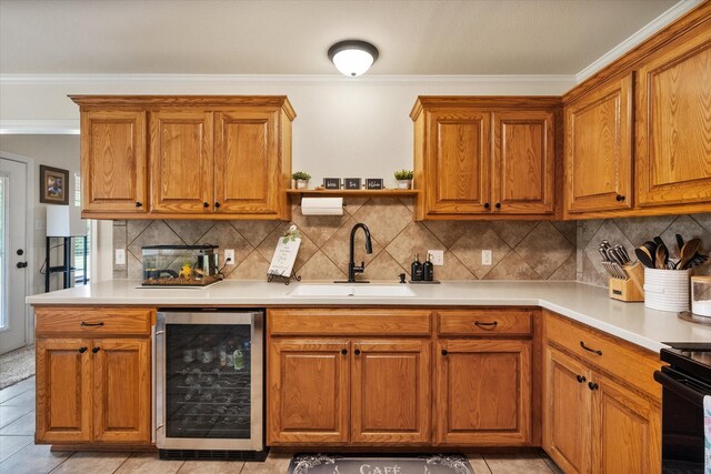 kitchen with wine cooler, light countertops, a sink, crown molding, and brown cabinetry