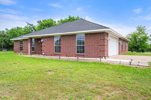 view of side of home featuring a yard, roof with shingles, concrete driveway, brick siding, and a garage