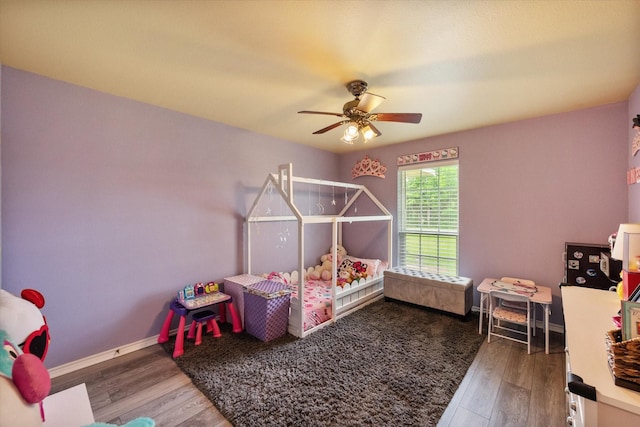 bedroom with ceiling fan, baseboards, and wood finished floors