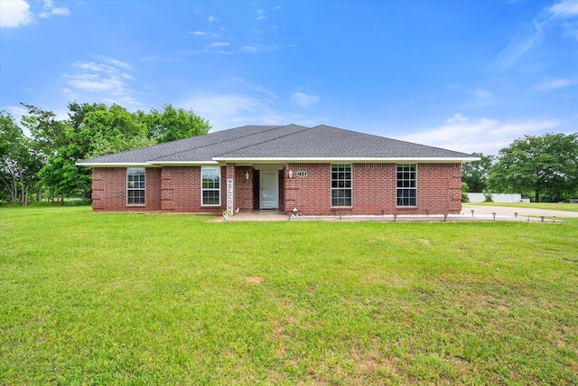 ranch-style home with brick siding, a shingled roof, and a front lawn