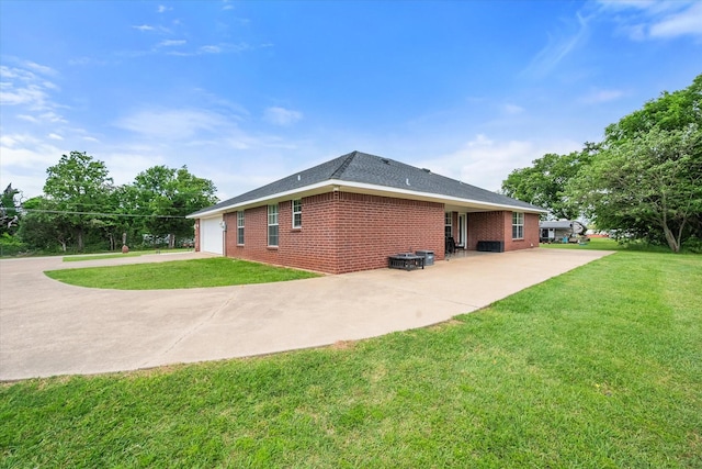 back of house featuring brick siding, a yard, and driveway