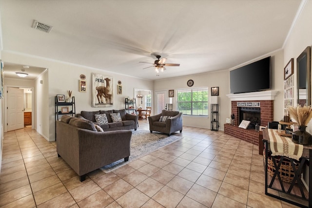 living area with crown molding, a ceiling fan, visible vents, and light tile patterned flooring